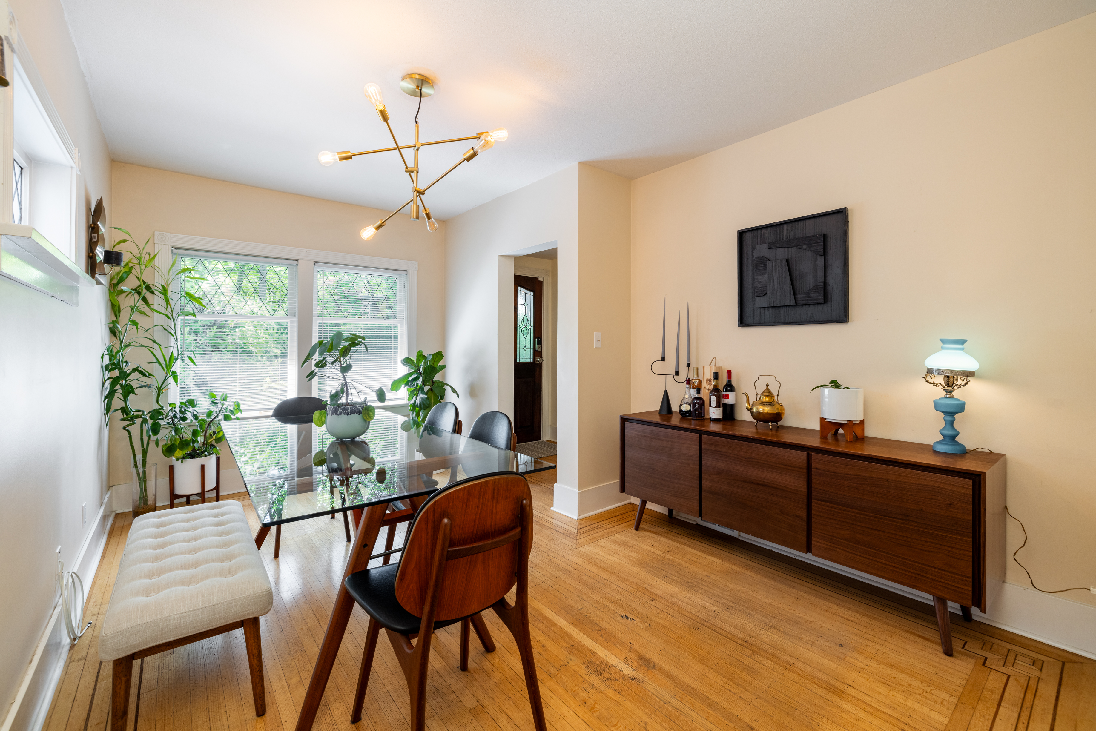 Dining room with mid-century walnut credenza and glass-top table