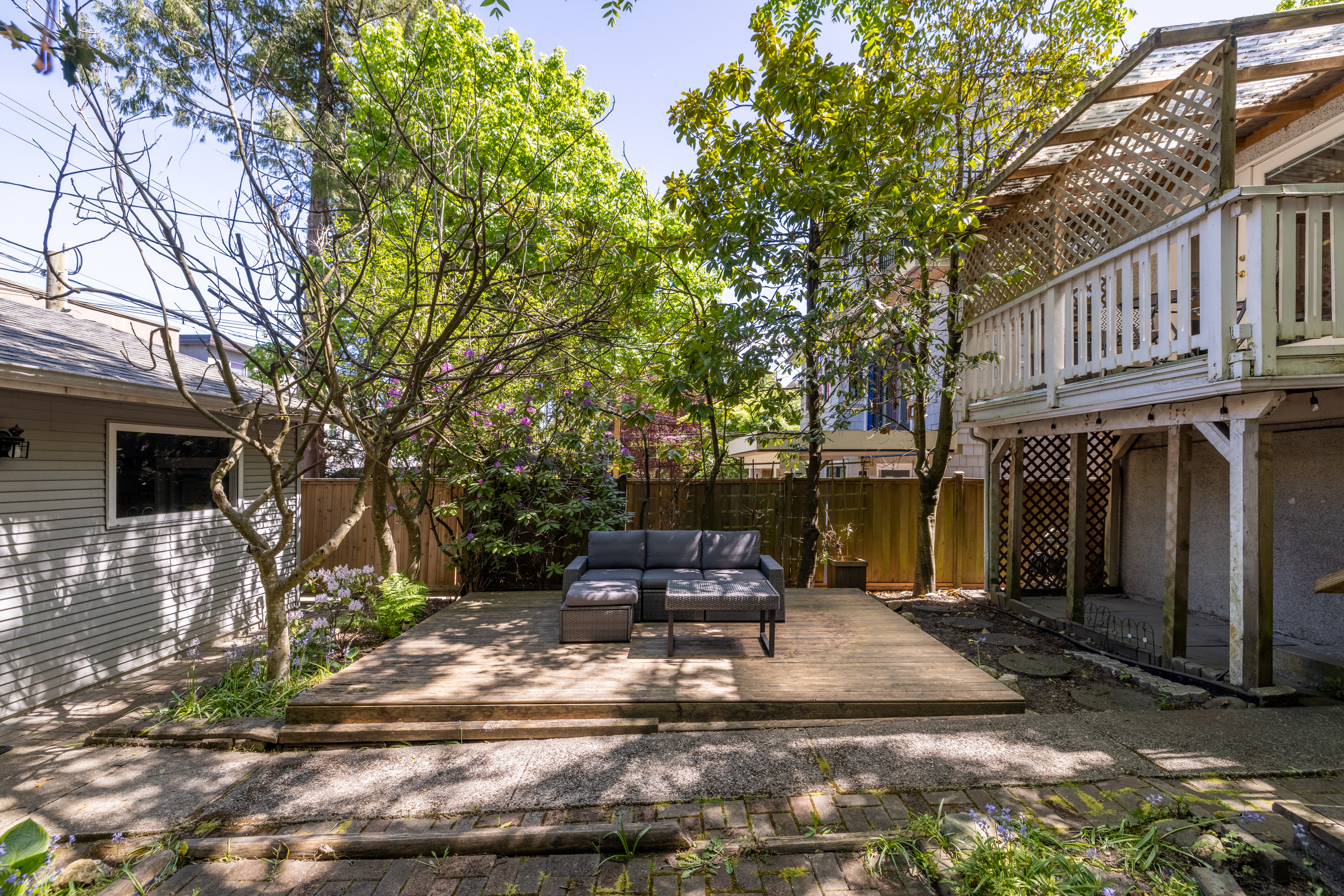View of the rear deck, lattice work and mature greenery from the garden
